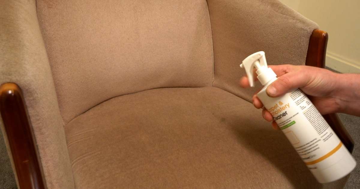 Using upholstery cleaner on a fabric chair Spraying upholstery cleaner onto fabric